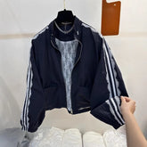 Black jacket with white stripes on sleeves held by a hand against a white background